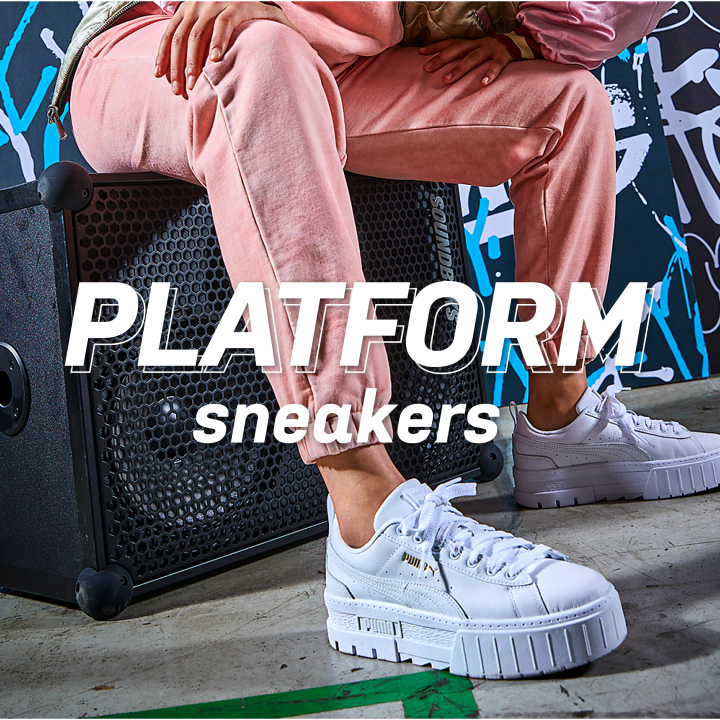 jente sitter på høytaler med puma platformsneakers